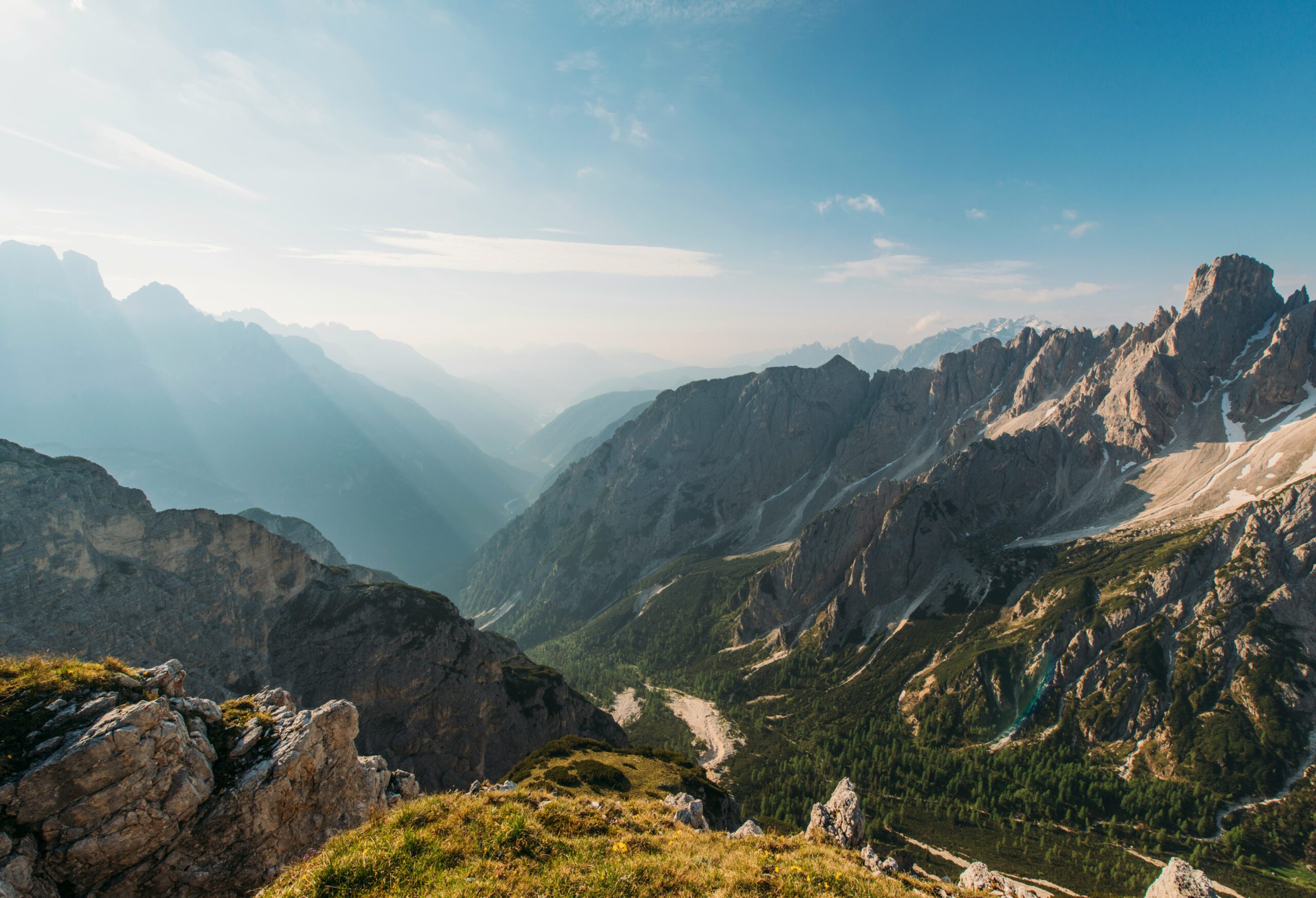 Mountain landscape with valleys and rugged peaks under blue sky