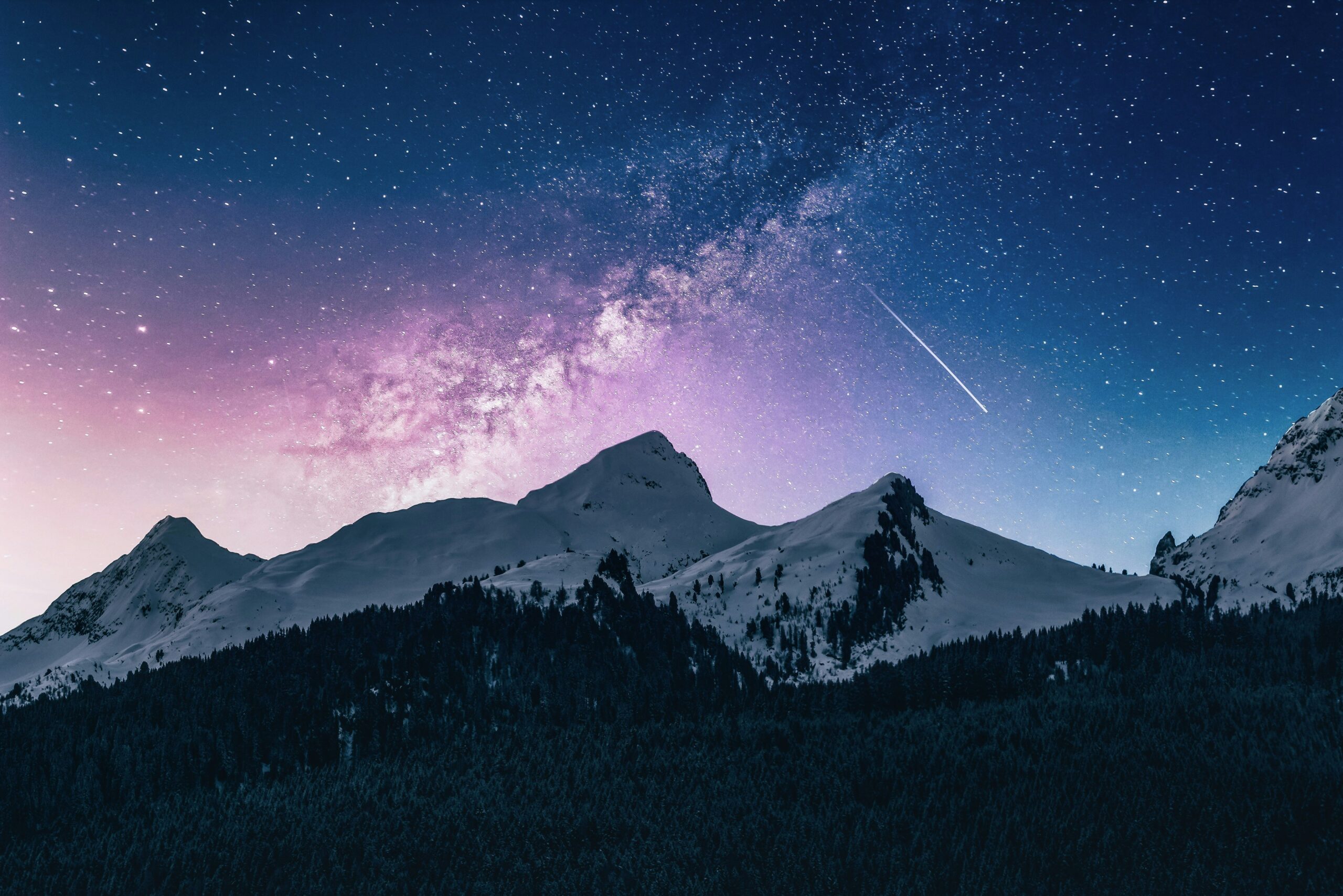 Mountain landscape under starry sky with Milky Way.