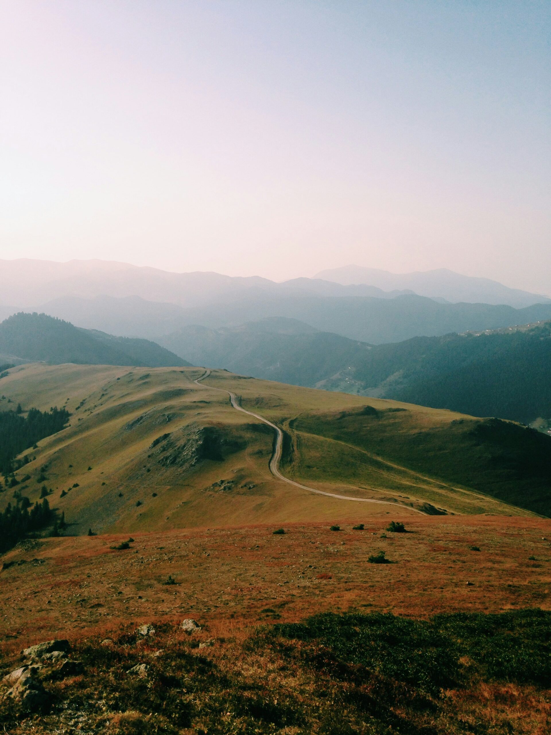 Mountain landscape with winding path and distant peaks.