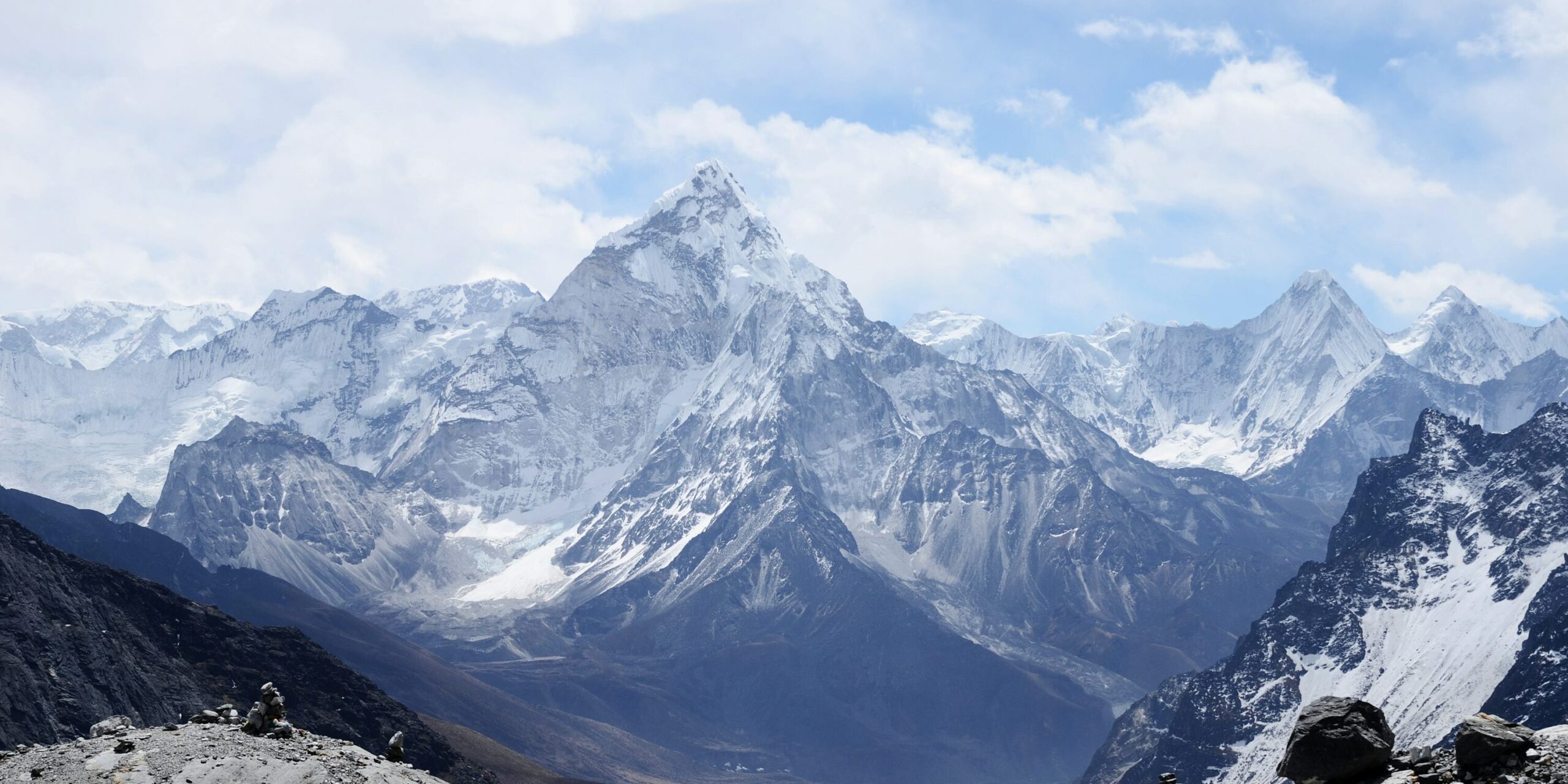 Snow-covered mountain range under a blue sky, daytime scene