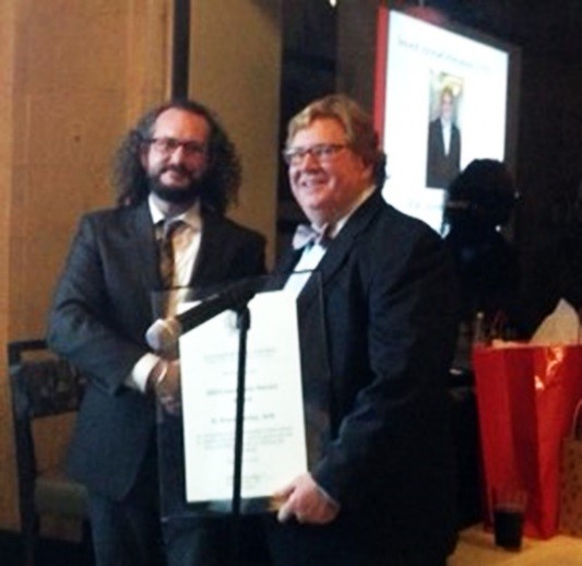 Dewberry's Philip Condley, past president of AIA Eastern Oklahoma, presents Bruce Henley (right) with the Community Service Award.